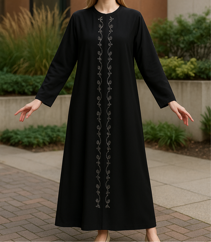 Jeune fille portant une abaya noire longue avec broderies argentées verticales au centre – disponible de 8 à 15 ans.