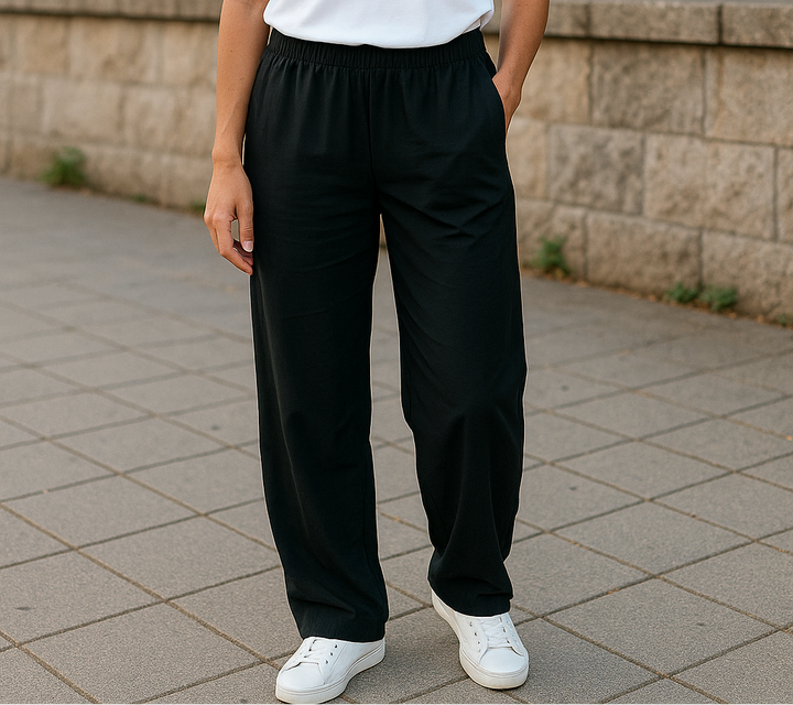 Femme portant un pantalon noir en Tencel fluide, coupe droite avec taille élastique, taille unique convenant du S au XL.