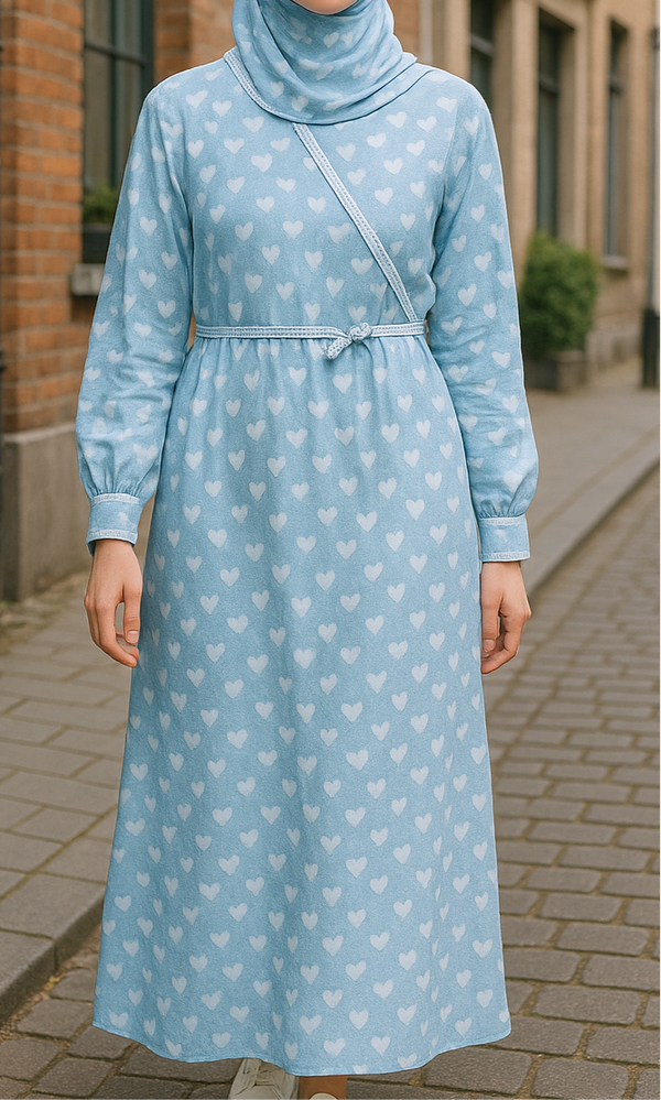Fille portant une robe de prière bleue à motifs cœurs avec un khimar assorti – disponible pour les filles de 8 à 15 ans.