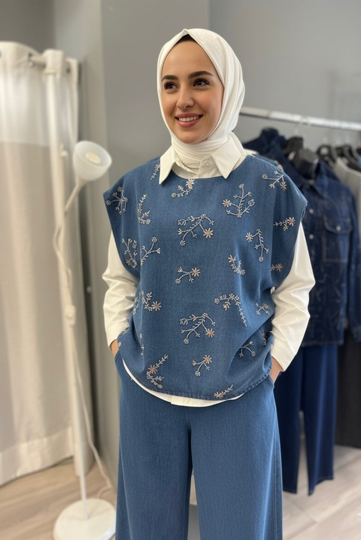 Modest 3-piece summer outfit featuring a white cotton shirt, straight-cut denim pants, and a sleeveless denim vest with gold strass embroidery, styled with a brown hijab and white sneakers