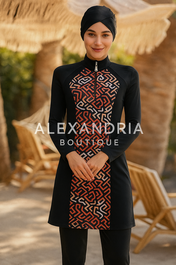 Femme portant un burkini noir avec un imprimé graphique rouge et beige sur le devant, debout dans un décor d’été avec des chaises longues en bois